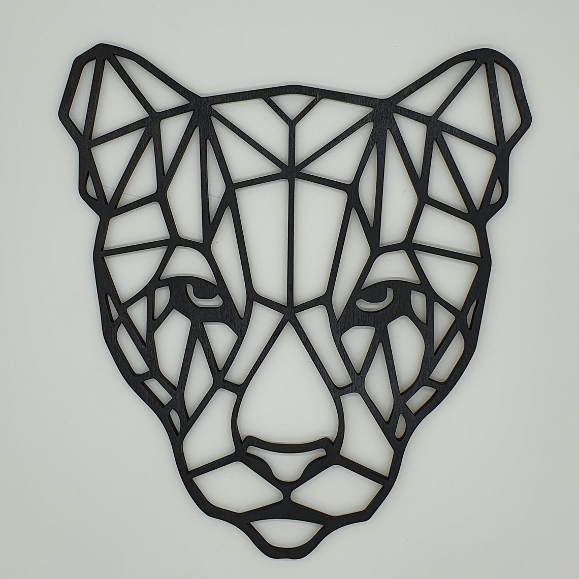 "Geometric panther face wall art in black MDF wood on a white background – modern animal wall decor"