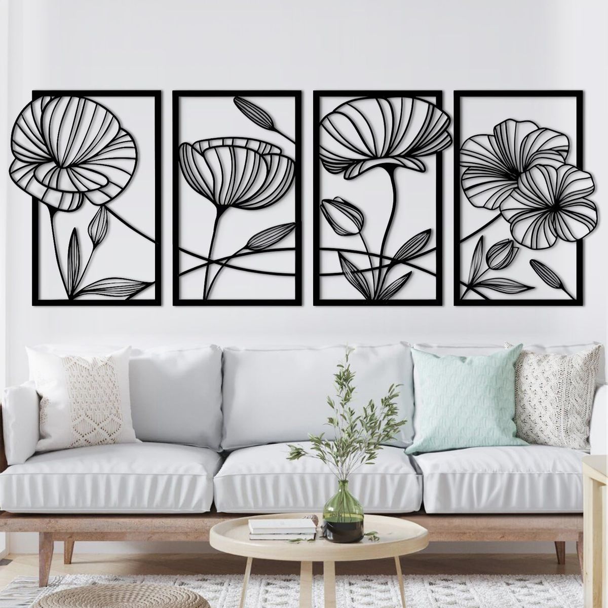 "Set of 4 black floral outline wall art panels mounted above a white sofa in a modern living room."