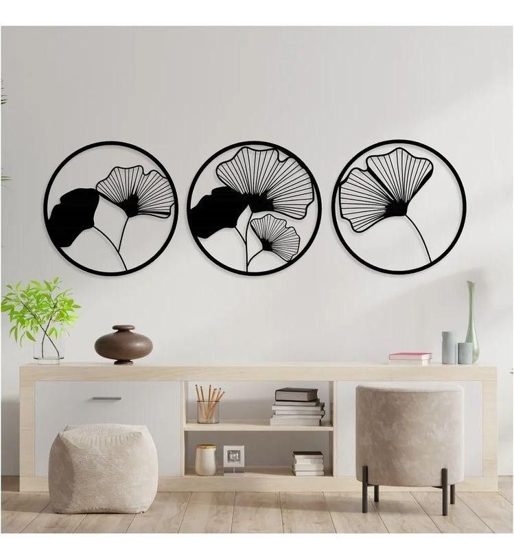 "Set of 3 round black wooden wall art panels with tropical leaf design mounted above modern console in minimalist living room"