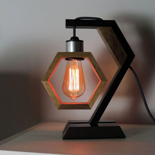 "Geometric hexagon wooden table lamp with Edison bulb, black metal base, and grey socket on a desk"