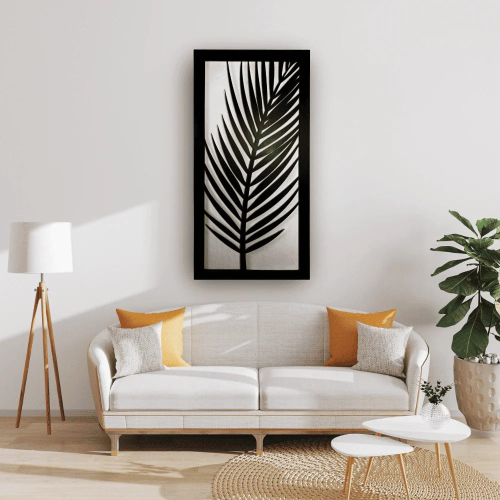 Modern living room with a white sofa, decorative pillows, and a framed leaf print on the wall.