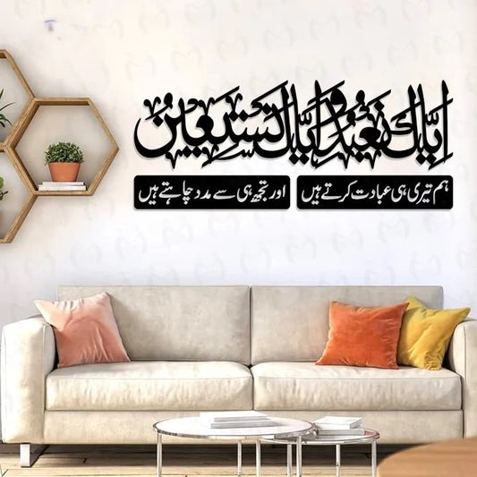 "Islamic wall art above a beige sofa featuring Surah Al-Fatiha in Arabic and Urdu calligraphy."