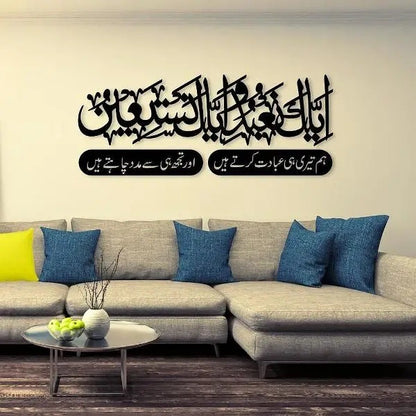 "Islamic wall art above a beige sofa featuring Surah Al-Fatiha in Arabic and Urdu calligraphy."