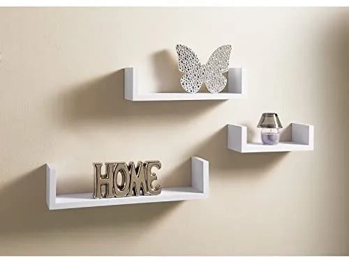 "Set of three minimalist floating wall shelves on a grey wall with books, plants, and decor items."