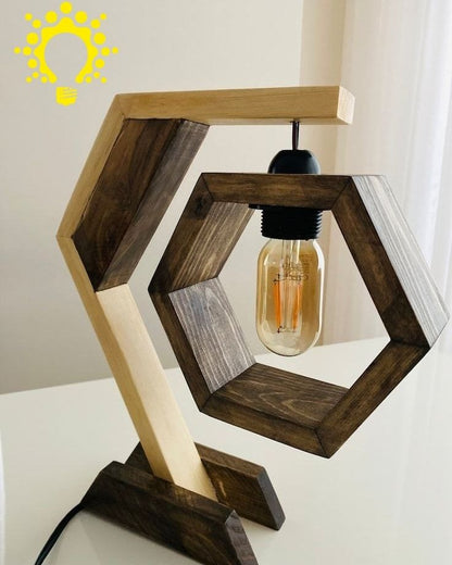 "Geometric hexagon wooden table lamp with Edison bulb, black metal base, and grey socket on a desk"
