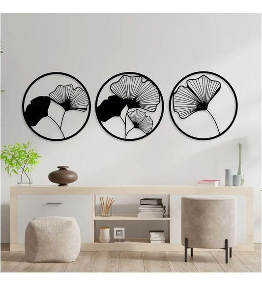 "Set of 3 round black wooden wall art panels with tropical leaf design mounted above modern console in minimalist living room"