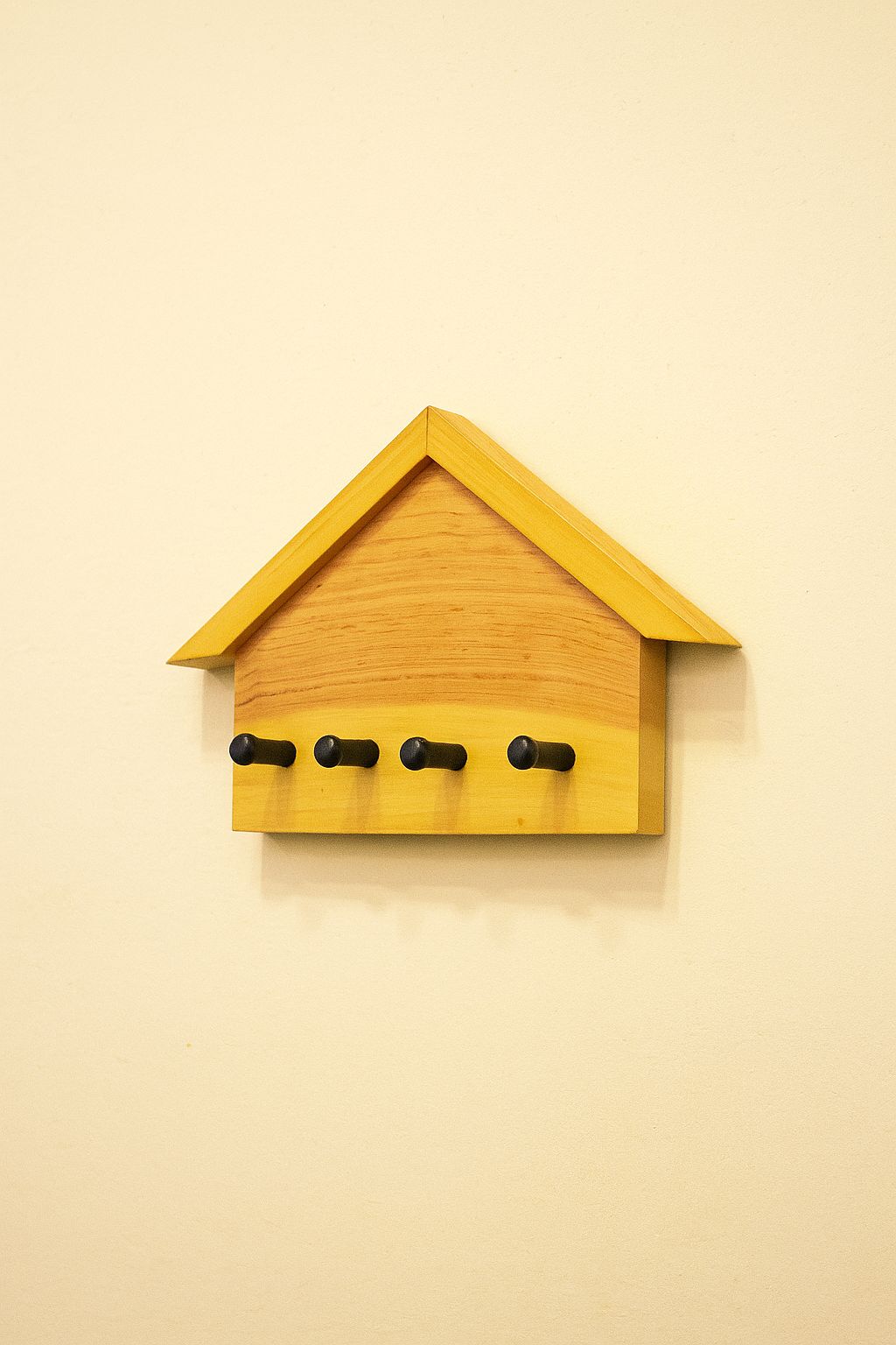 wooden house-shaped key holder mounted on wall