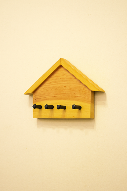 wooden house-shaped key holder mounted on wall
